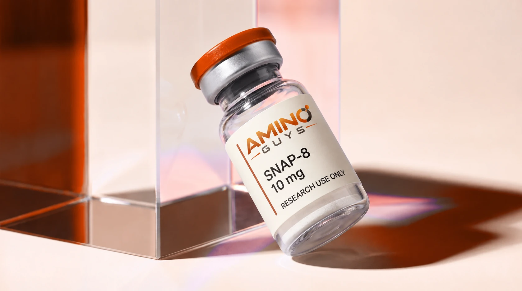 One Amino Guys SNAP-8 10 mg vial with an orange cap and a thin white powder puck, leaning against glass in warm prismatic light